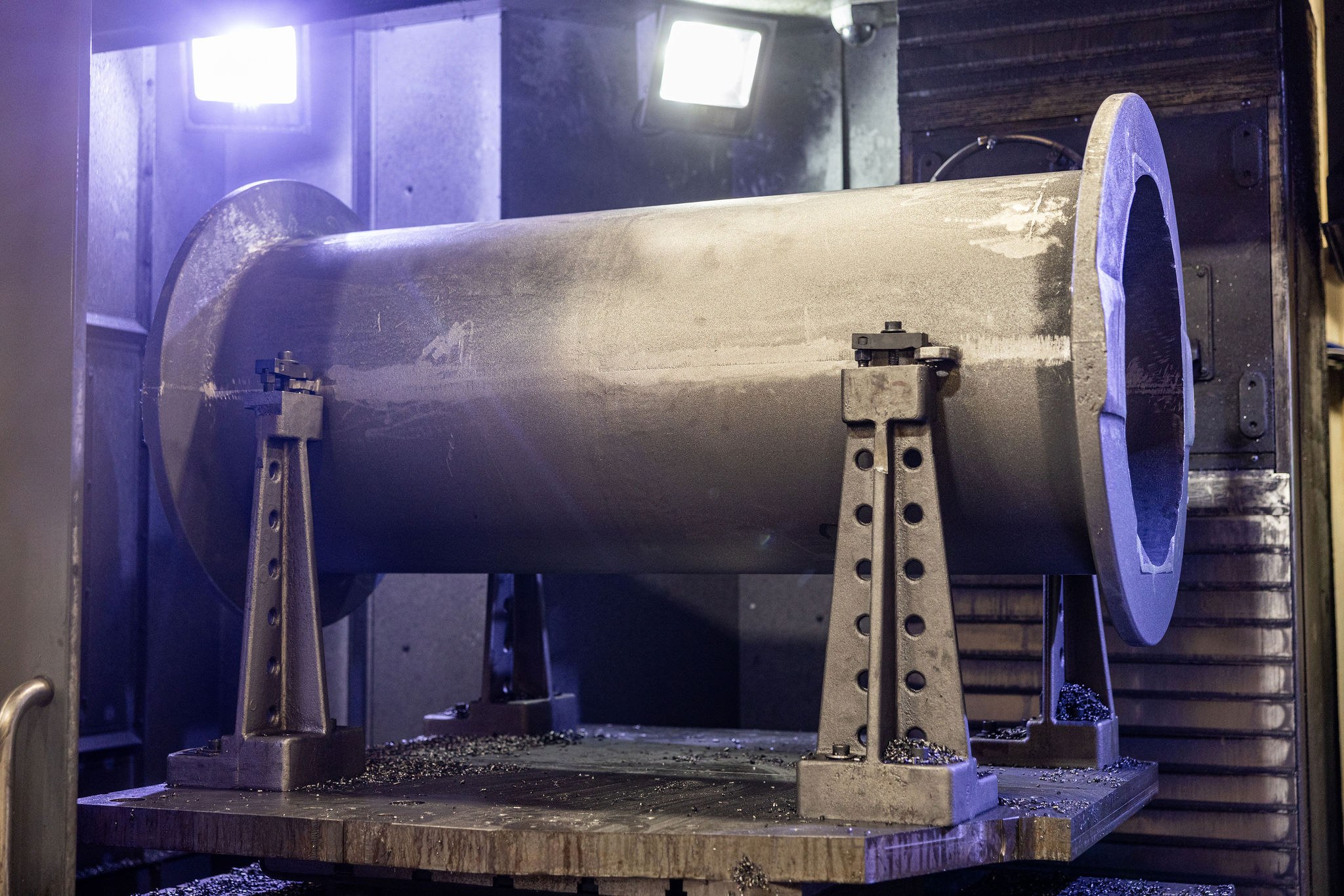A large cast cylindrical section fixtured on a CNC machining center for finish-machining of critical bores and mounting faces after pour and heat treat.