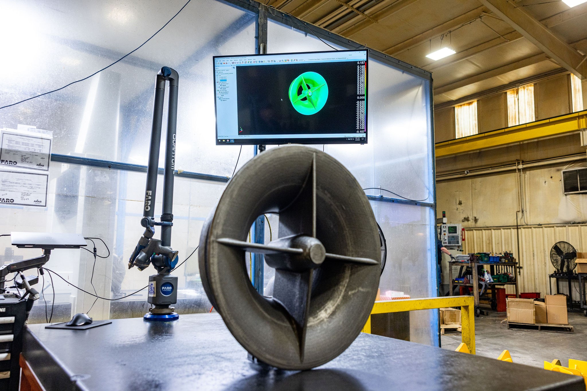 Engineer reviewing a 3D-scanned cast part on screen — point cloud and CAD model overlaid for digital-twin reconstruction of a worn industrial casting.