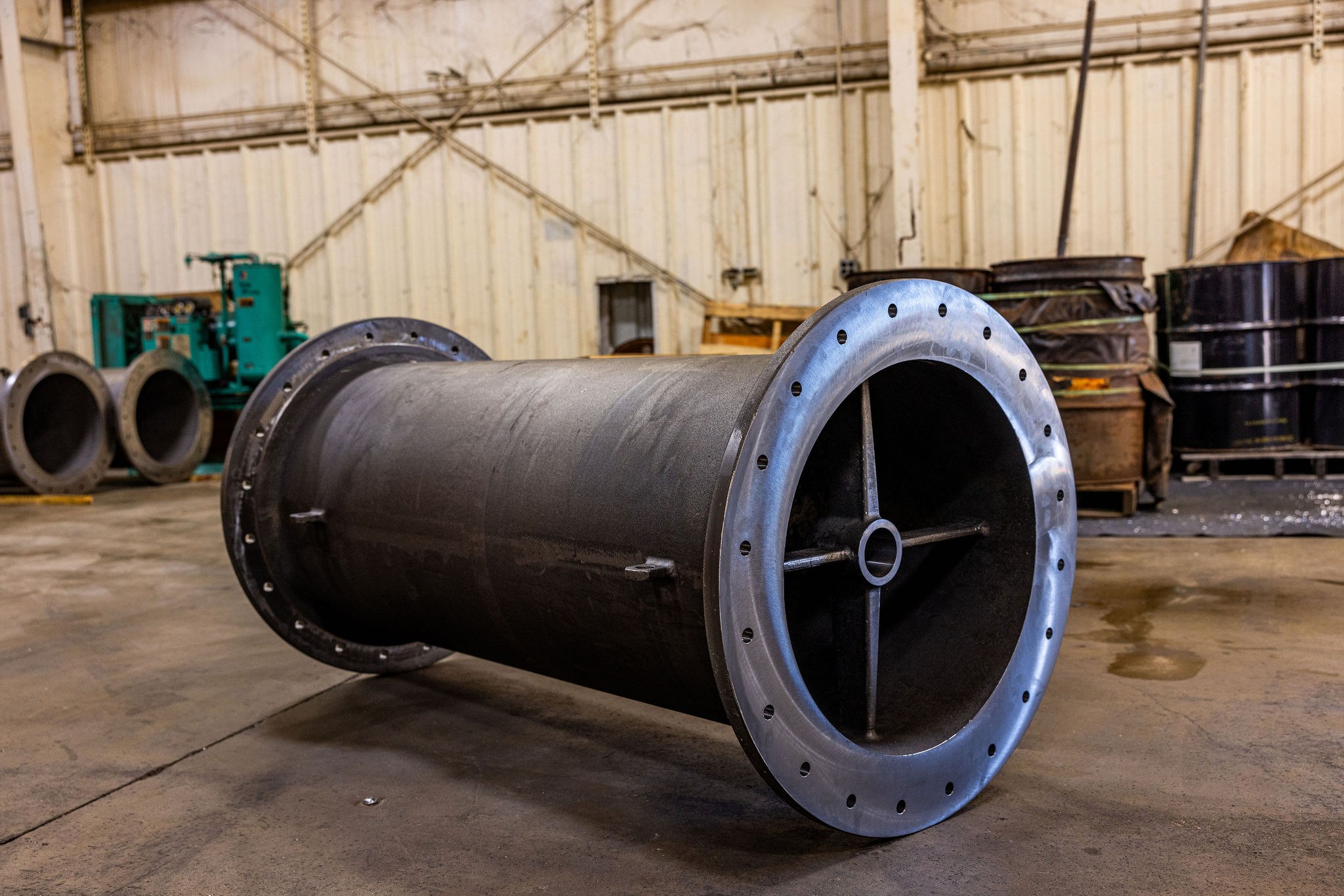 Near-net-shape cast pipe / fitting section on the shop floor — representative of the ductile-iron and cast carbon-steel body work we run at the 1 to 100 piece scale for municipal water and wastewater equipment.